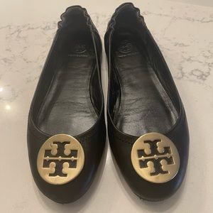 Tory Burch Black flats with gold medallion.